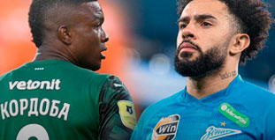 Двое футболистов на поле: один в зеленой, другой в голубой форме, рядом, сосредоточенные взгляды